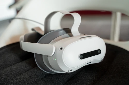 A pair of gray VR glasses lies on an armchair.