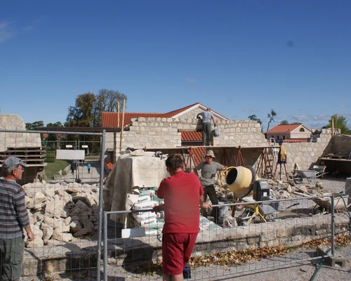 Bauarbeiten am Haus des Ölhändlers, Arbeiter bei den Bauarbeiten und halb aufgestellte Wände 
