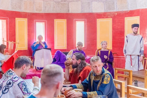 Reenactor in spätantiker Gewandung feiern ein pompöses Mahl in der Villa Urbana in Carnuntum.