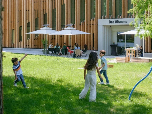 Restaurant garden of Bistro Das Altoona with children playing in the foreground, viewed from Altoonapark.