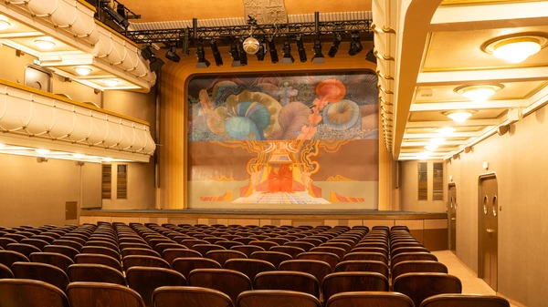 leerer Theatersaal mit großem Luster und Gemälde am Eisernen Vorhang