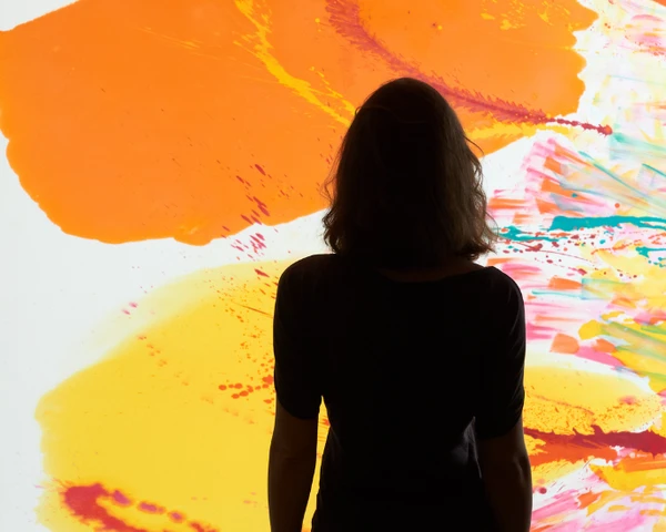 Woman in front of large wall artwork