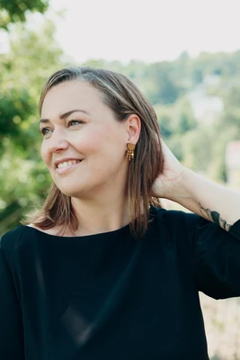 dunkelhaarige Person mit großem Ohrring