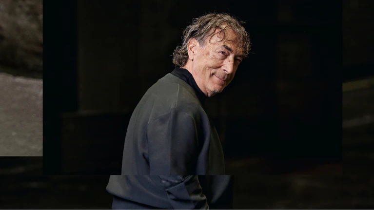 Portrait photo of Hubert von Goisern in front of a dark background.