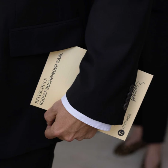 A man is holding the folder from the Rudolf Buchbinder Hall