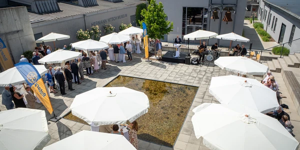Menschen mit Schirmen auf einer Piazza