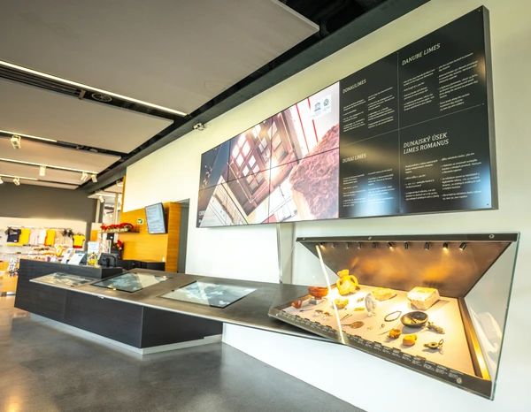 Limes-Infostelle im Eingangsbereich des Standortes Petronell. Vitrine und Pult mit Funden und Bildern zu Carnuntum und dem Donaulimes 