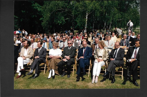 LH Stellvertreter Pröll sitzt mit Publikum auf Holzsesseln in Freilichtgelände von Carnuntum bei Eröffnung 1996 