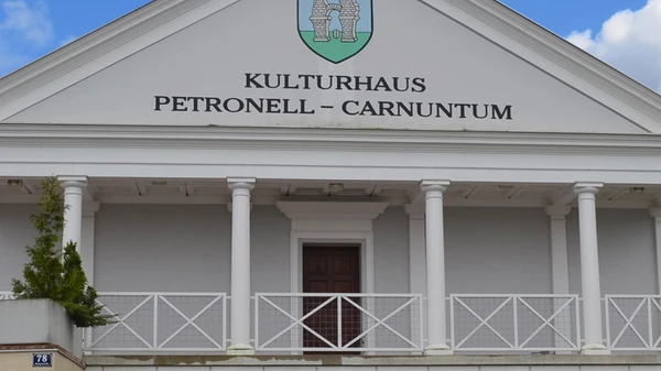 Exterior view of the Cultural Center of Petronell-Carnuntum Cultural Center. The building is modeled after a Roman temple with white columns. 