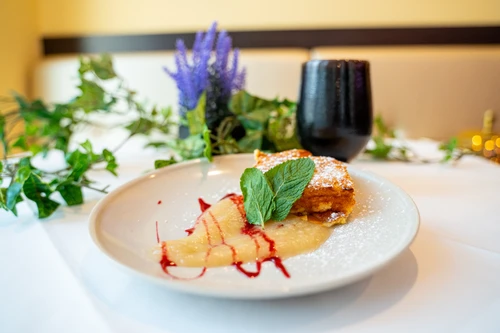 Eine Nachspeise nach römischem Rezept vor Efeu, Lavendel und einem dunklen Trinkgefäß im Hintergrund.