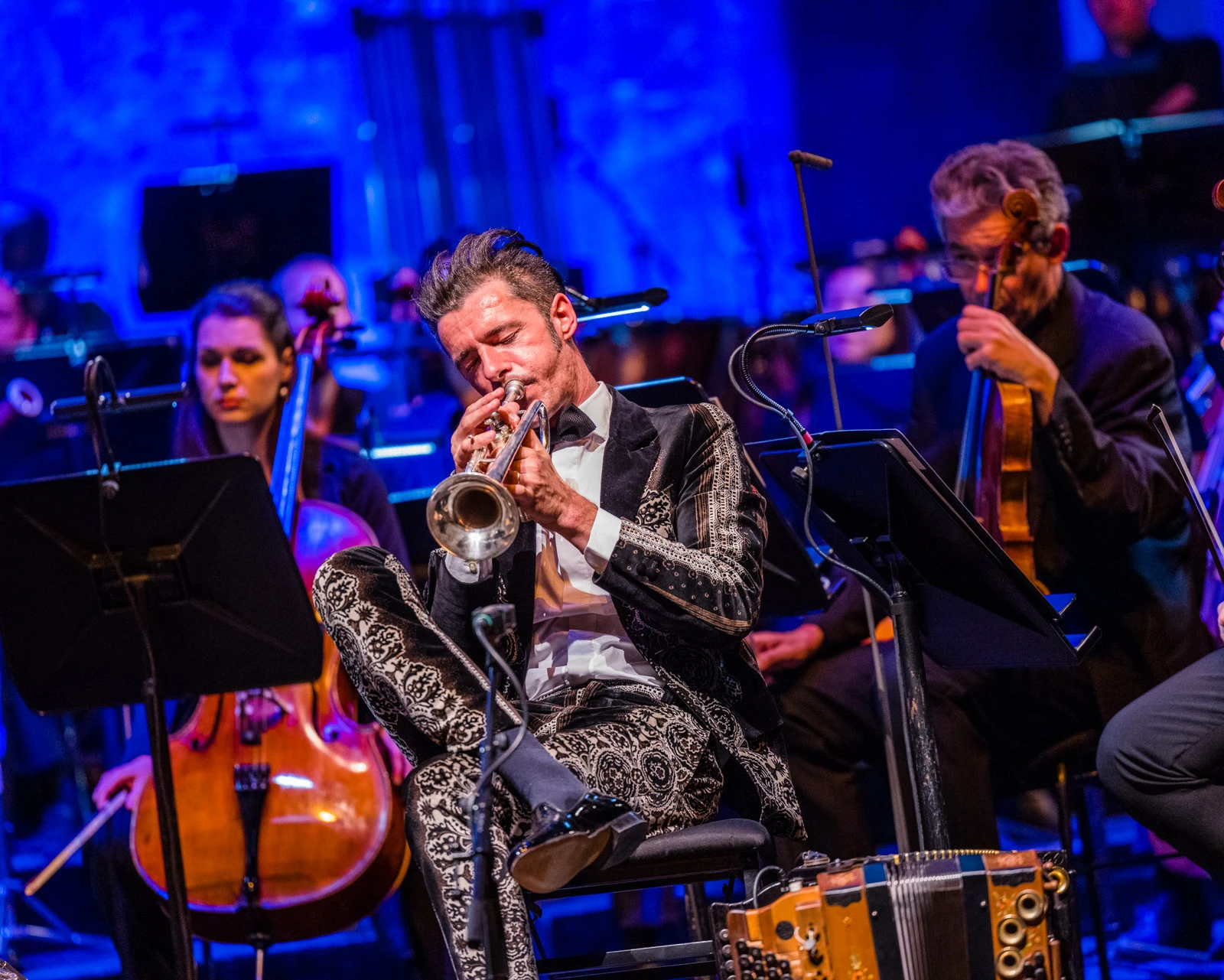 Mann spielt in Orchester sitzend Trompete