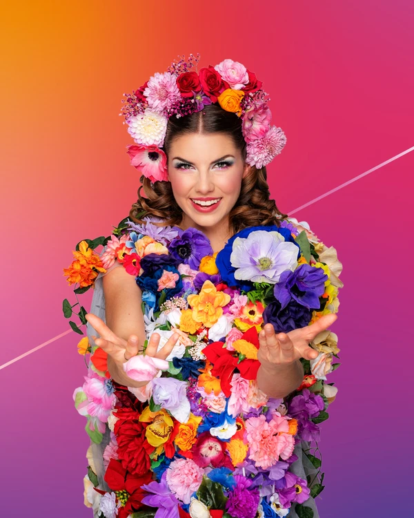 A person is entirely adorned with colorful flowers, including a floral crown, set against a gradient background.