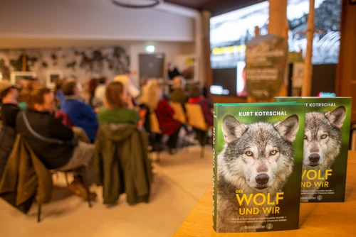 Veranstaltung im Foyer des Haus der Wildnis, im Vordergrund das Buch "Der Wolf und Wir" des Vortragenden Kurt Kotrschal. 