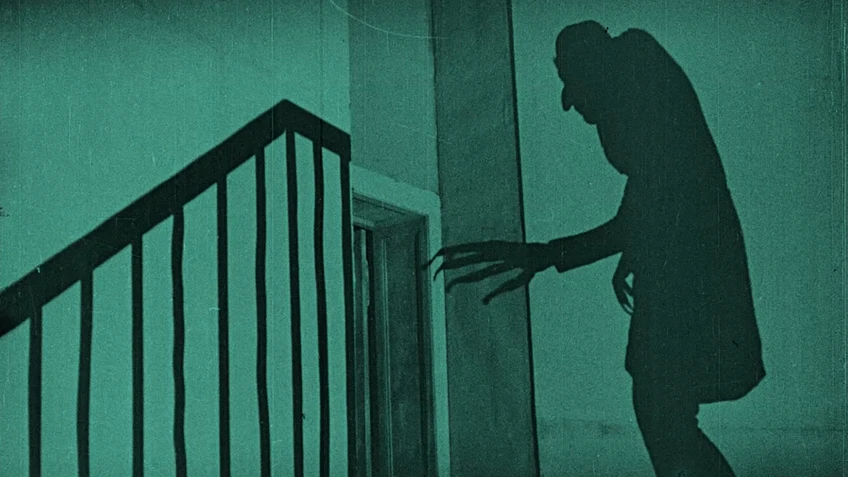 Schatten an einer grauen Wand, buckelige Gestalt mit langen Krallen