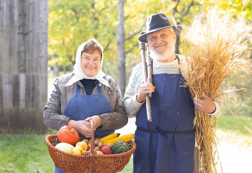 Mann und Frau in ländlicher Kleidung und Gemüse