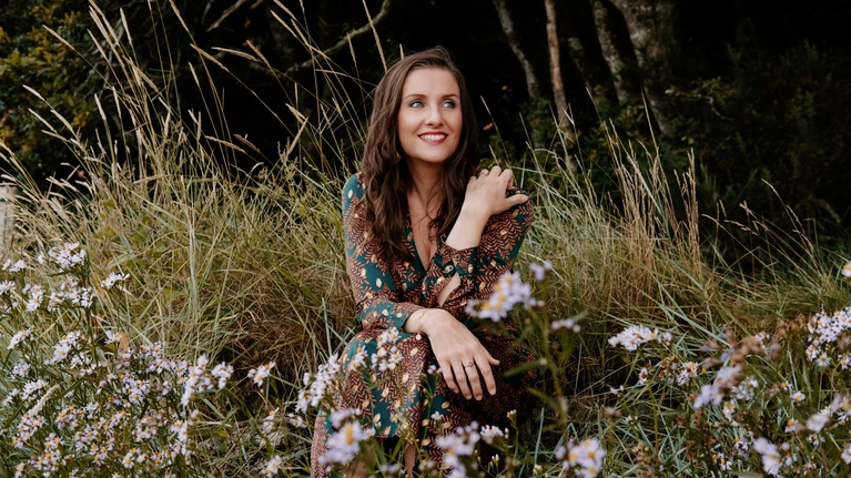 Solistin als Sopranistin Elsa Benoit in einem Blumenfeld.