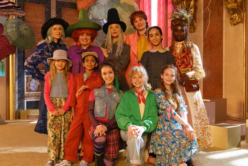 Kinder und Erwachsene in bunten Kostüme, als Gruppe zusammengestellt in einer Art Theaterkulisse