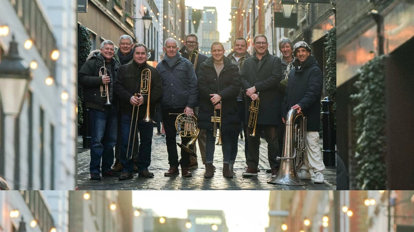 A photo of the London Brass Ensemble with their brass instruments in front of an urban (London) street.