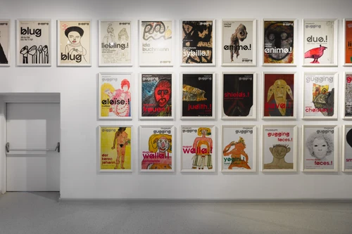 Blick in einen hellen Gang der Dauerausstellung im Museum Gugging mit großformatigen Plakaten an den Wänden.