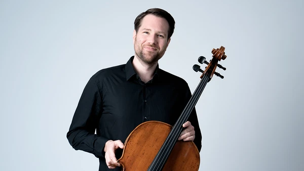 Portraitfoto von Sebastian Dozler mit Cello