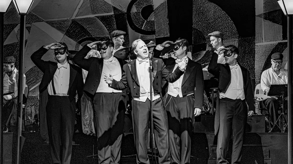 Singend: Alfred  (Gerhard Kasal), dahinter v.l.n.r. in Maske in die Ferne blickend: Prinz Orlofsky (Moritz Mausser), Frank (Jakob Semotan), Dr. Falke  (Peter Lesiak), Gabriel von Eisenstein (Raphael von Bargen)