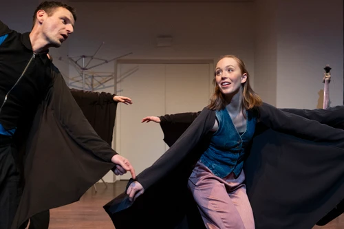Fotoimpression aus dem Probenprozess zu "Fledermäuse" von der schallundrauch agency. Performer:innen tragen schwarze Capes, die sie ausbreiten, als seien sie Fledermäuse.