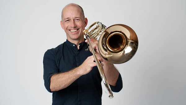 Portraitfoto von Wolfgang Gastager mit Posaune