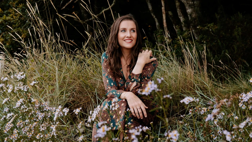 Solistin als Sopranistin Elsa Benoit in einem Blumenfeld.