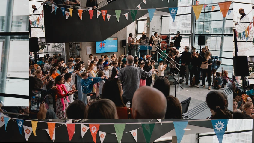 Foto vom BIG BANG Festival mit singenden Kindern im bunt dekorierten Festspielhaus St. Pölten.