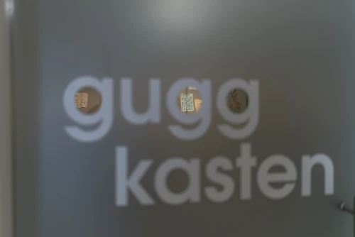 eine Tür wo drauf steht guggkasten. Durch die Buchstabe g erkennt man einen Raum in der Tiefe