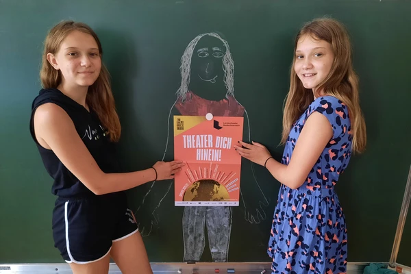 Zwei Kinder zeigen auf ein Plakat