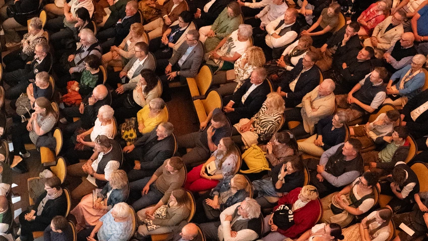 Zuschauer in einem Theatersaal, von oben fotografiert
