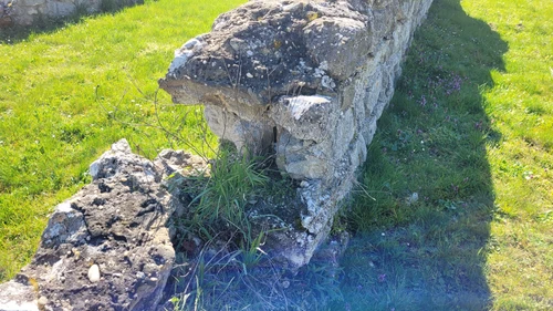 Steinmauern im Amphitheater, die stark beschädigt sind und auf Restaurierung warten.