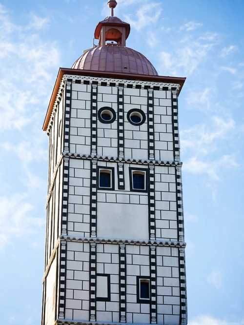 Hochturm: weißer Turm mit schwarzem Scraffito-Rechteck-Muster