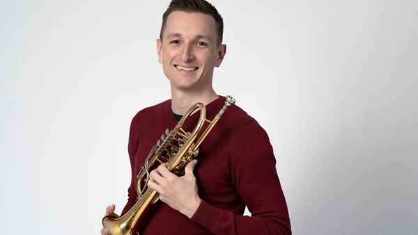 Portraitfoto von Patrick Hofer mit Trompete