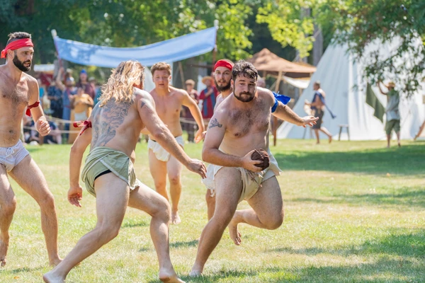 Men playing harpastum at the Carnuntum 2024 time travel event, man running away from others with a ball