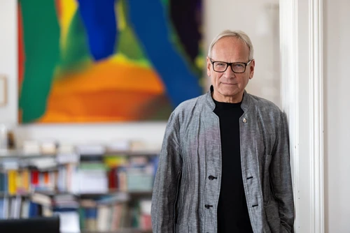 Theologe und Psychotherapeut Arnold Mettnitzer steht in einem Raum