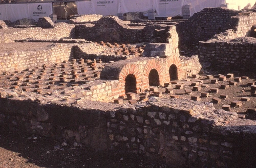 Historical photograph of the thermal baths in the Roman Quarter, showing brick heating arches and walls
