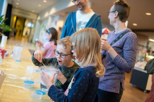 Kinder staunen über ein Experiment.