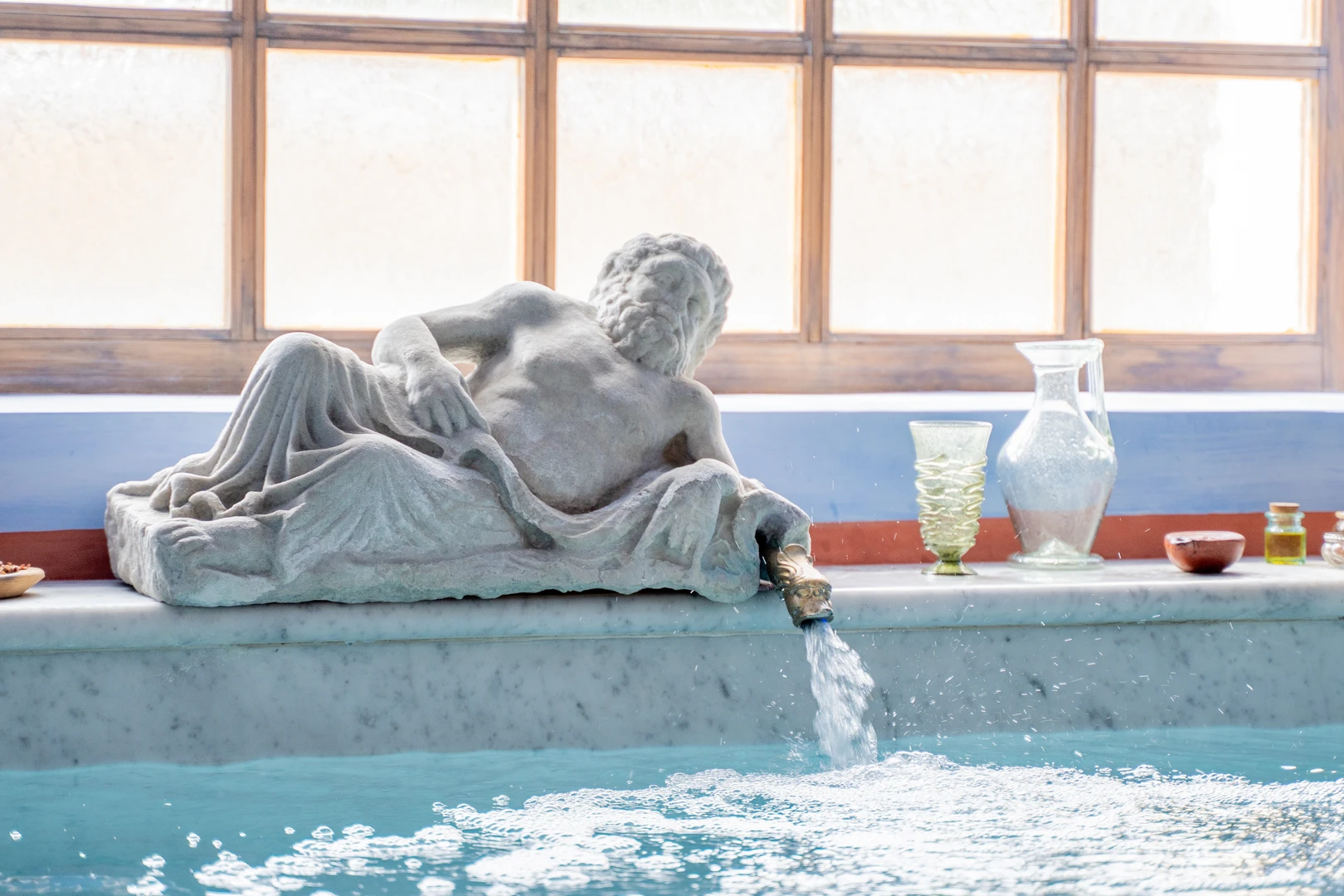 A reclining statue of Danuvius in the frigidarium of the thermal baths; water flows from the reclining god into the pool. 
