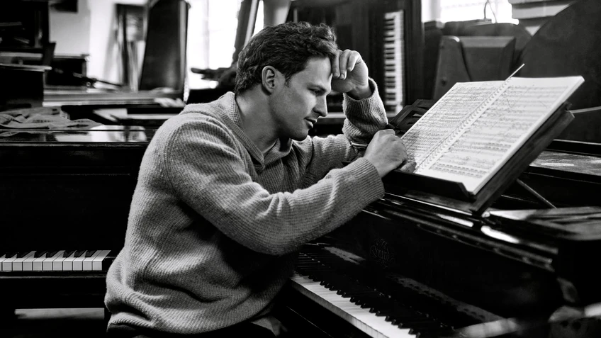 Black and white portrait photograph of conductor Andreas Otensamer at the piano.