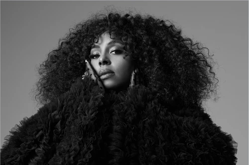 Schwarz/Weiß-Porträtfoto der Musikerin Ledisi in einem großen schwarzen Mantel.