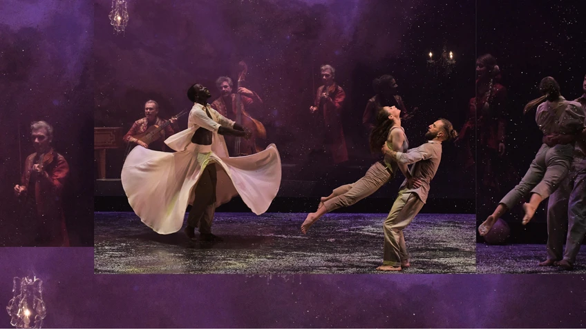 Performancefoto aus dem Tanzstück "Kaléidoscope", choreografiert von Mourad Merzouki, getanzt von der Compagnie Käfig. Mehrere Tänzer:innen performen in Paaren eine synchrone Choreografie, ein einzelner Tänzer in weißem Kostüm steht mit wallendem weißen Rock und sticht heraus. Im Hintergrund vor einem schwarzen Bühnenhintergrund stehen Musiker:innen, ihre Instrumente spielend.