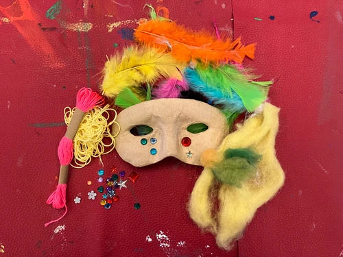 eine bunte Maske und Federn