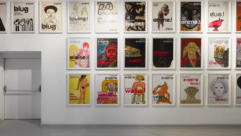 Blick in einen hellen Gang der Dauerausstellung im Museum Gugging mit großformatigen Plakaten an den Wänden.