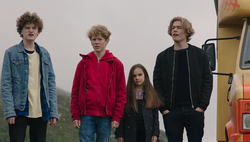 Vier Kinder verschiedenen Alters neben einem gelben Wohnmobil