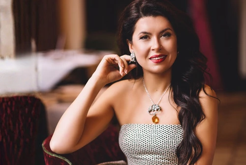 Dunkelhaarige Dame mit Schmuck, ihre Hand am Ohrring