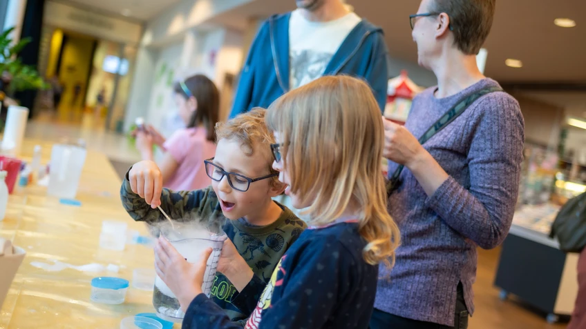 Kinder staunen über ein Experiment.