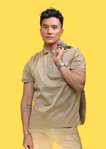 Portraitfoto von Vincent Bueno vor gelbem Hintergrund. 