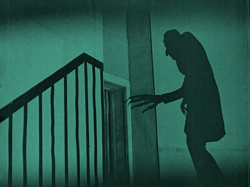 Schatten an einer grauen Wand, buckelige Gestalt mit langen Krallen